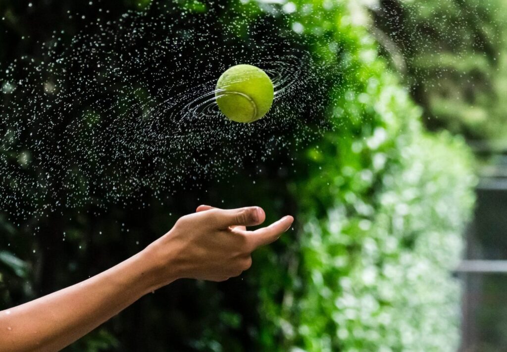 person throwing tennis ball