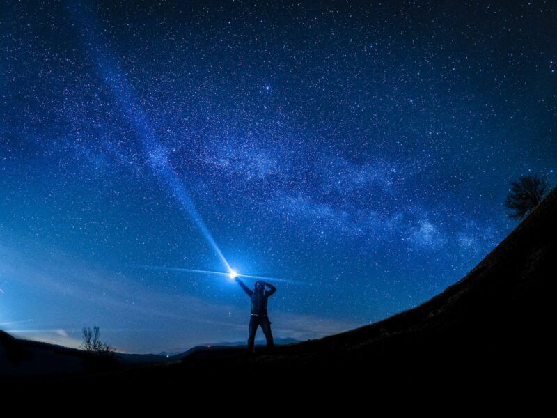 silhouette of man holding flashlight